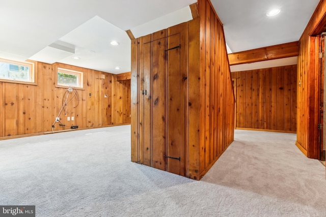 bonus room with recessed lighting, carpet flooring, and wood walls