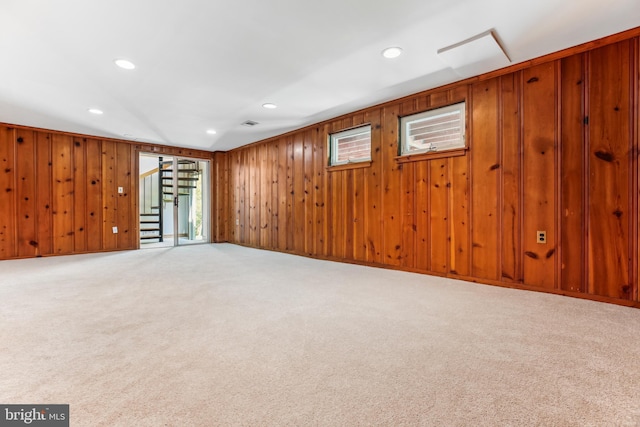 basement featuring wooden walls, stairway, carpet, and recessed lighting