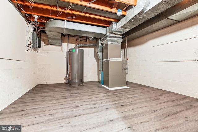 unfinished below grade area with water heater, concrete block wall, heating unit, and wood finished floors
