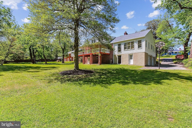view of yard with a wooden deck and driveway