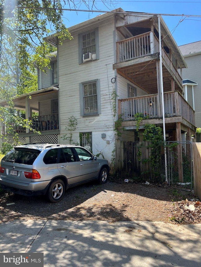 exterior space with fence, a balcony, and cooling unit