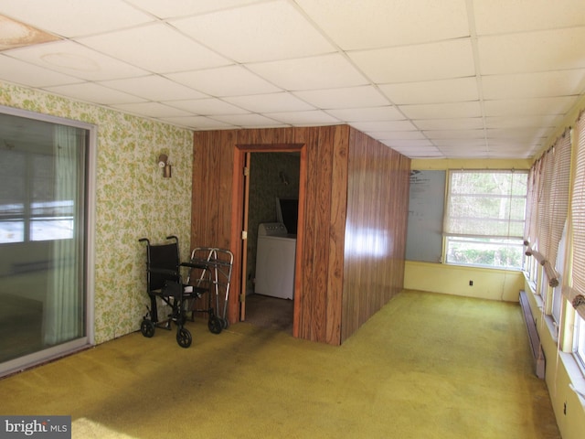 interior space with washer / clothes dryer, wallpapered walls, a drop ceiling, and carpet floors
