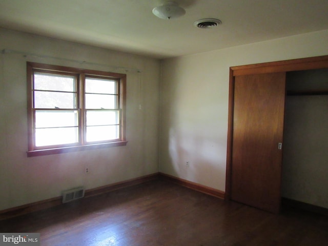 unfurnished bedroom featuring visible vents, baseboards, and wood finished floors