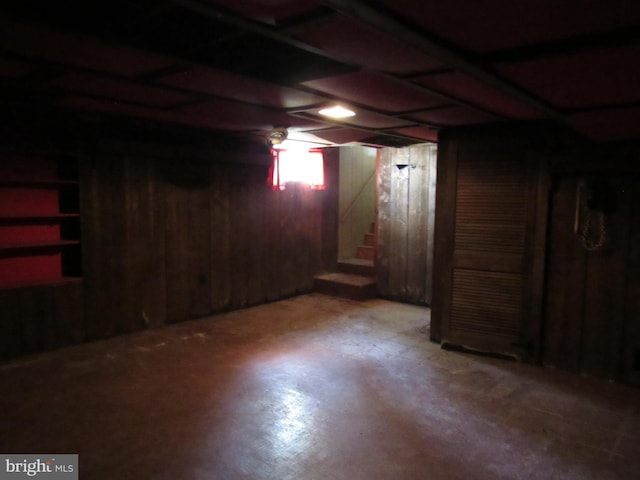 unfinished below grade area featuring stairway and wood walls