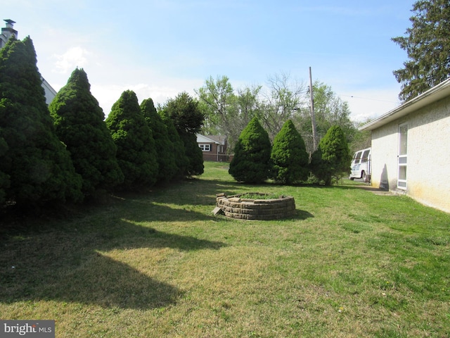 view of yard featuring an outdoor fire pit