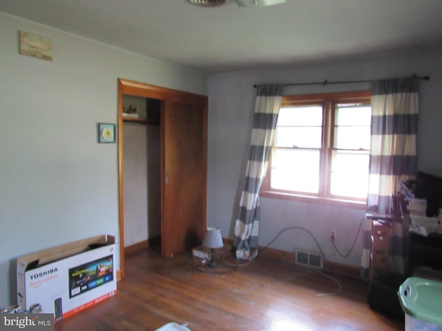 unfurnished bedroom with visible vents, wood finished floors, and a closet