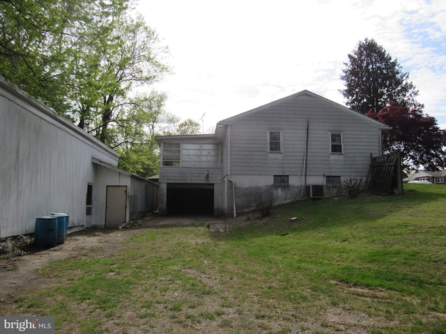 view of side of property with a lawn, driveway, and a garage