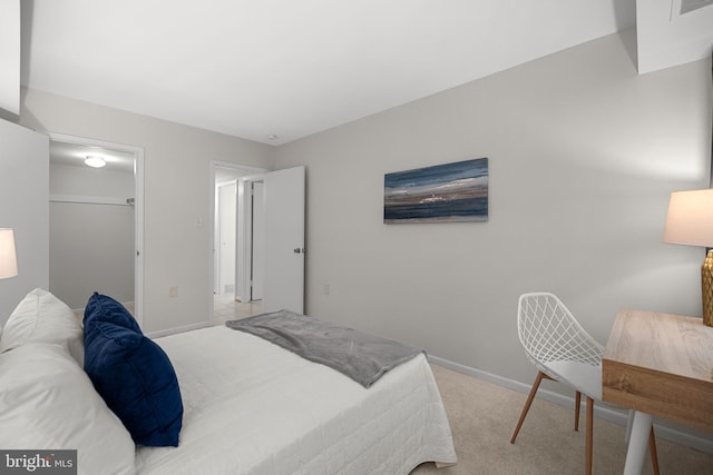 bedroom with visible vents, a closet, baseboards, carpet floors, and a walk in closet