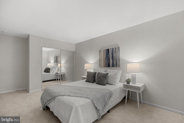 carpeted bedroom with baseboards and a closet