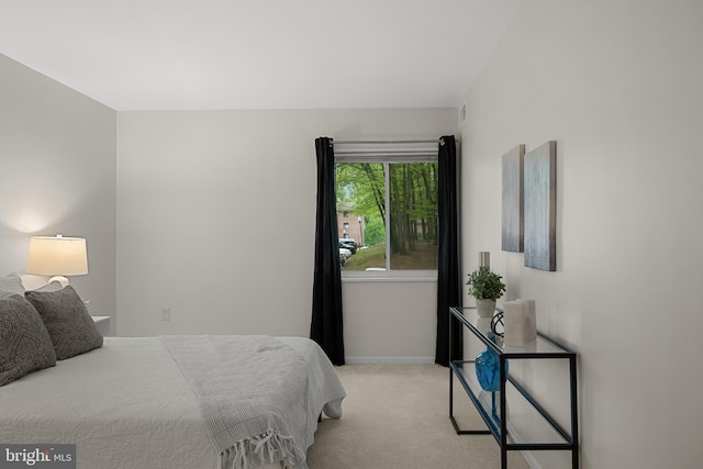 bedroom with baseboards and light carpet