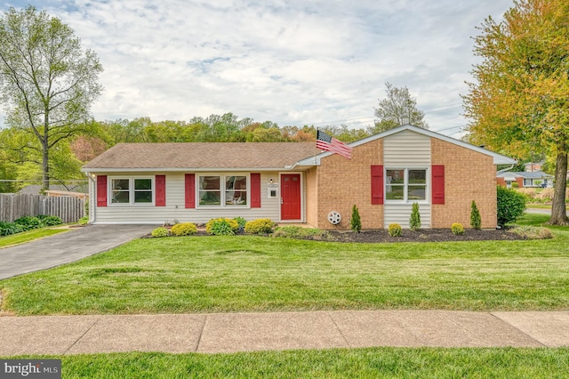 ranch-style home featuring a front lawn and fence
