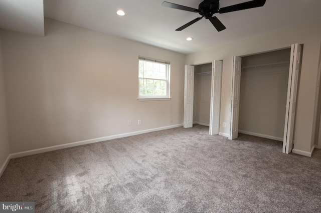 unfurnished bedroom featuring recessed lighting, carpet floors, and two closets