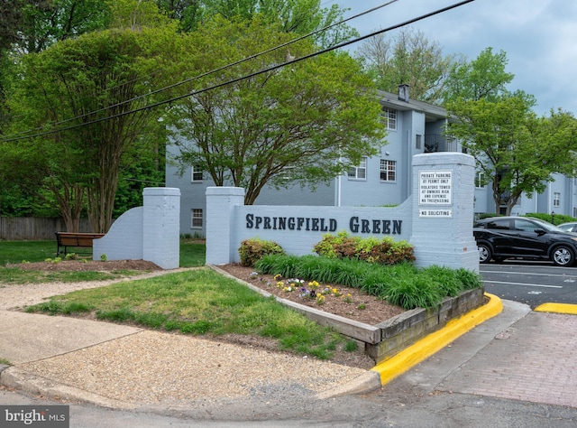 community sign with uncovered parking and fence