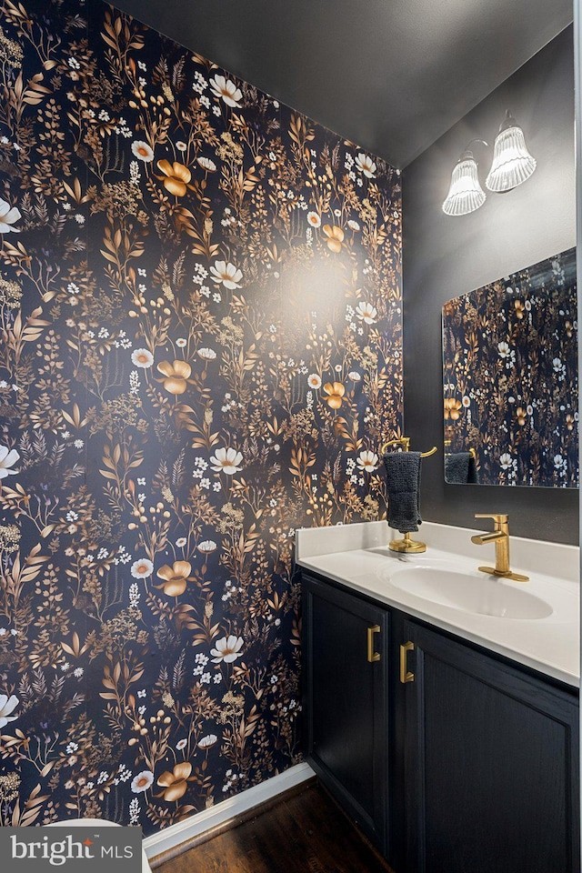 13215 Golders Green Pl, Bristow, VA 20136 - bathroom featuring wood finished floors, vanity, baseboards, and wallpapered walls
