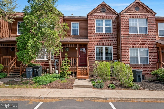 townhome / multi-family property featuring uncovered parking and brick siding
