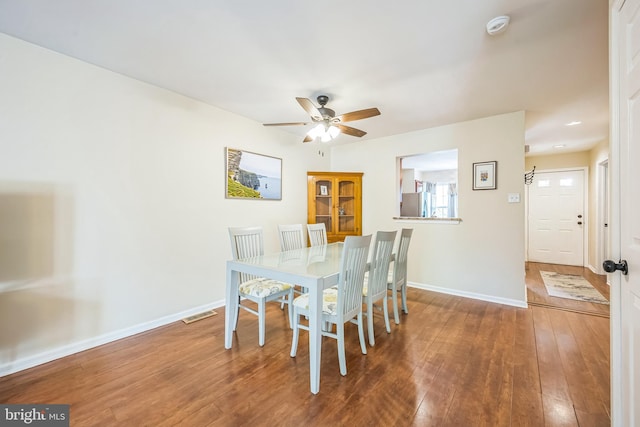 dining area with baseboards, visible vents, hardwood / wood-style flooring, and ceiling fan