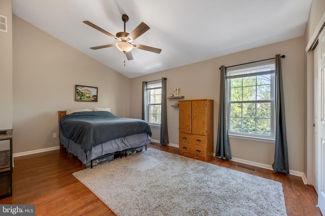 bedroom with lofted ceiling, visible vents, wood finished floors, and baseboards