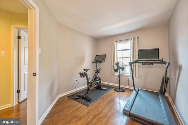 workout room featuring wood finished floors and baseboards