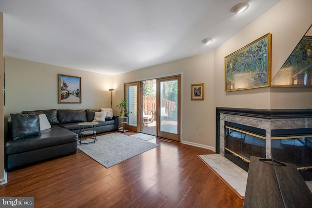 living room with a fireplace, wood finished floors, and baseboards