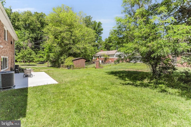 2300 Foster Pl, Temple Hills, MD 20748 - view of grassy yard featuring central air condition unit, a patio, a storage unit, and an outdoor structure