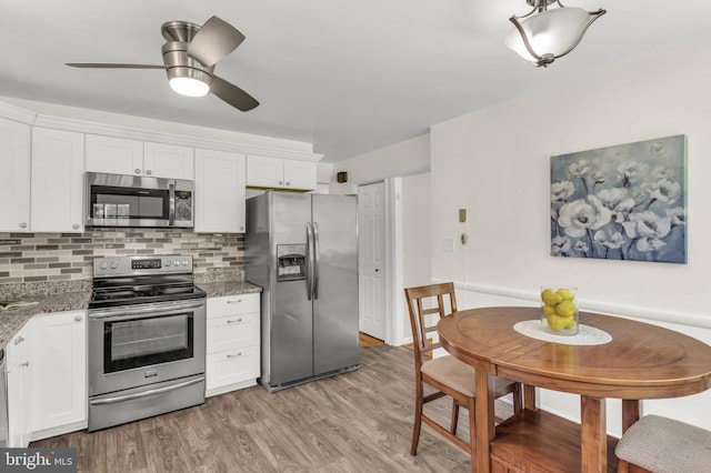 2300 Foster Pl, Temple Hills, MD 20748 - kitchen featuring appliances with stainless steel finishes, white cabinets, light stone counters, and light wood-type flooring