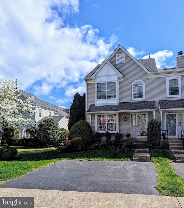 view of front of house with a chimney and a front lawn