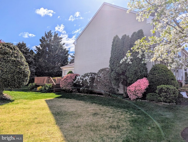 view of home's exterior with a deck and a lawn