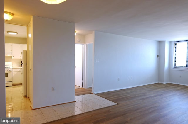 empty room with light wood-style flooring and baseboards