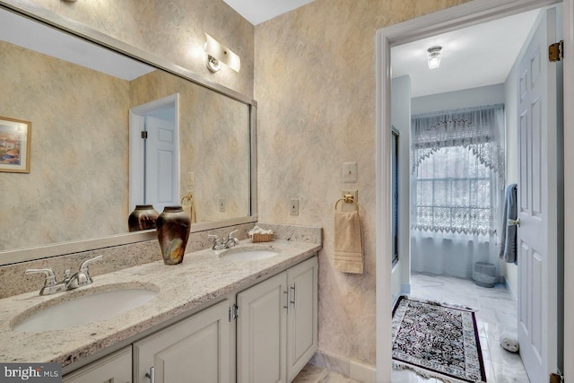 full bath featuring double vanity, marble finish floor, bath / shower combo with glass door, and a sink