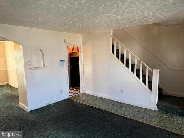 4333 Pimlico Rd, Baltimore, MD 21215 - unfurnished living room featuring carpet flooring, arched walkways, a textured ceiling, baseboards, and stairway