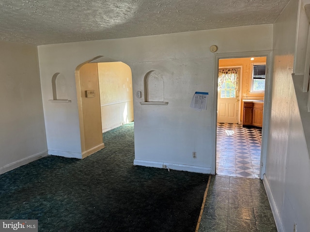 4333 Pimlico Rd, Baltimore, MD 21215 - unfurnished room featuring baseboards, arched walkways, and a textured ceiling