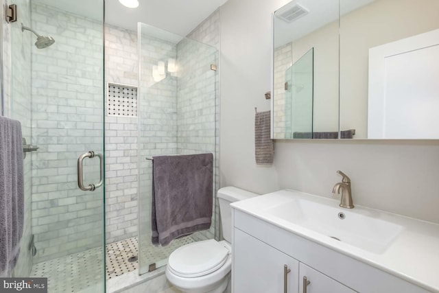bathroom with visible vents, a shower stall, toilet, and vanity
