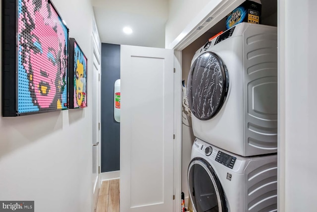 laundry room featuring stacked washer and dryer, baseboards, light wood-type flooring, recessed lighting, and laundry area