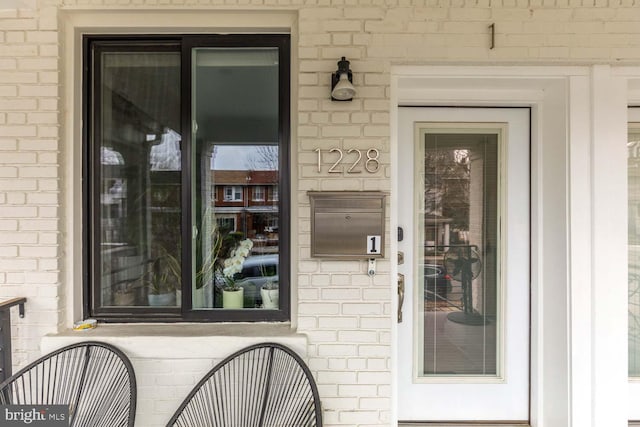 view of exterior entry with brick siding