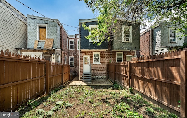 19 W 29th St, Wilmington, DE 19802 - rear view of property featuring entry steps, mansard roof, brick siding, and a fenced backyard