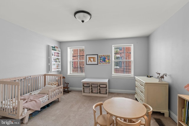 bedroom featuring a nursery area, carpet floors, and multiple windows