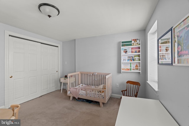 carpeted bedroom featuring a crib and a closet
