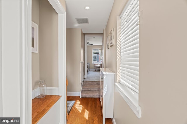 hall with visible vents and wood finished floors