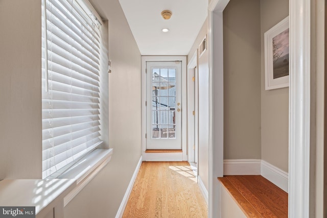 hall featuring light wood finished floors and baseboards
