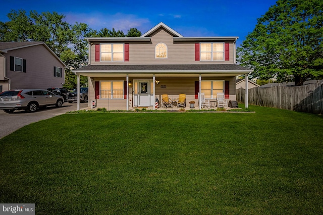 view of front of property with fence, covered porch, and a front lawn