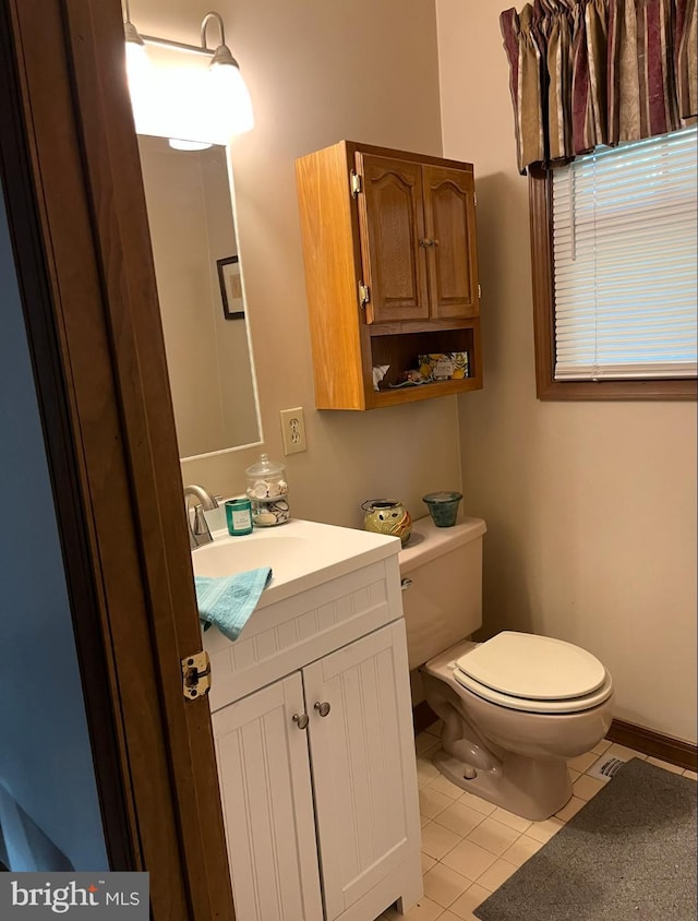 bathroom featuring vanity, tile patterned floors, and toilet