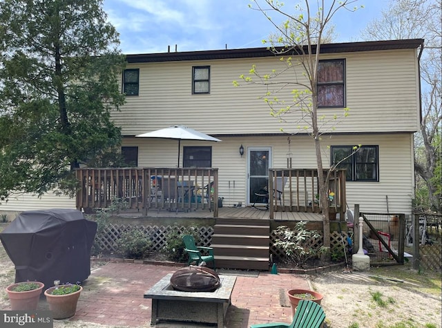 back of property with a patio, a wooden deck, and an outdoor fire pit