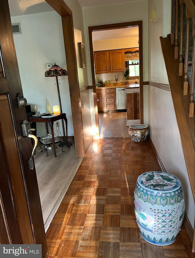 corridor featuring visible vents, baseboards, and stairway