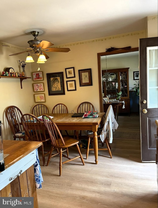dining area with a ceiling fan and light wood-style floors