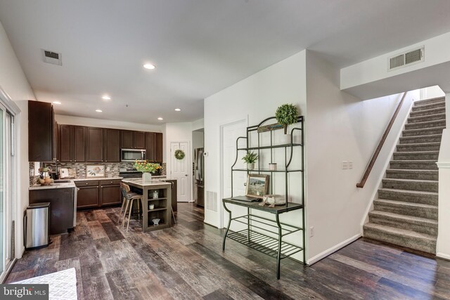 3560 Sherwin Dr, Manchester, MD 21102 - kitchen featuring stainless steel microwave, dark wood finished floors, light countertops, dark brown cabinets, and tasteful backsplash