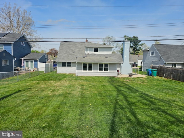 56 Coral Ln, Levittown, PA 19055 - rear view of house featuring a lawn, a patio, a fenced backyard, and roof with shingles