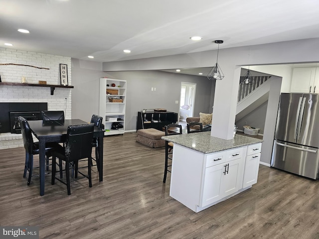 56 Coral Ln, Levittown, PA 19055 - kitchen with a fireplace, white cabinets, freestanding refrigerator, and dark wood-type flooring