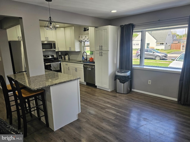 56 Coral Ln, Levittown, PA 19055 - kitchen with dark wood finished floors, dark stone counters, appliances with stainless steel finishes, white cabinets, and a sink