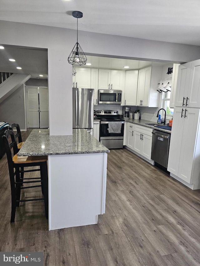 56 Coral Ln, Levittown, PA 19055 - kitchen featuring stainless steel appliances, stone counters, a kitchen island, white cabinetry, and dark wood finished floors