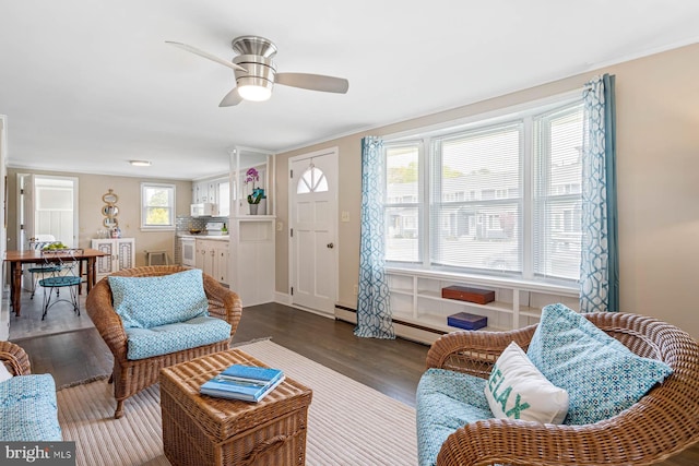 living room featuring dark wood-type flooring, a ceiling fan, and ornamental molding